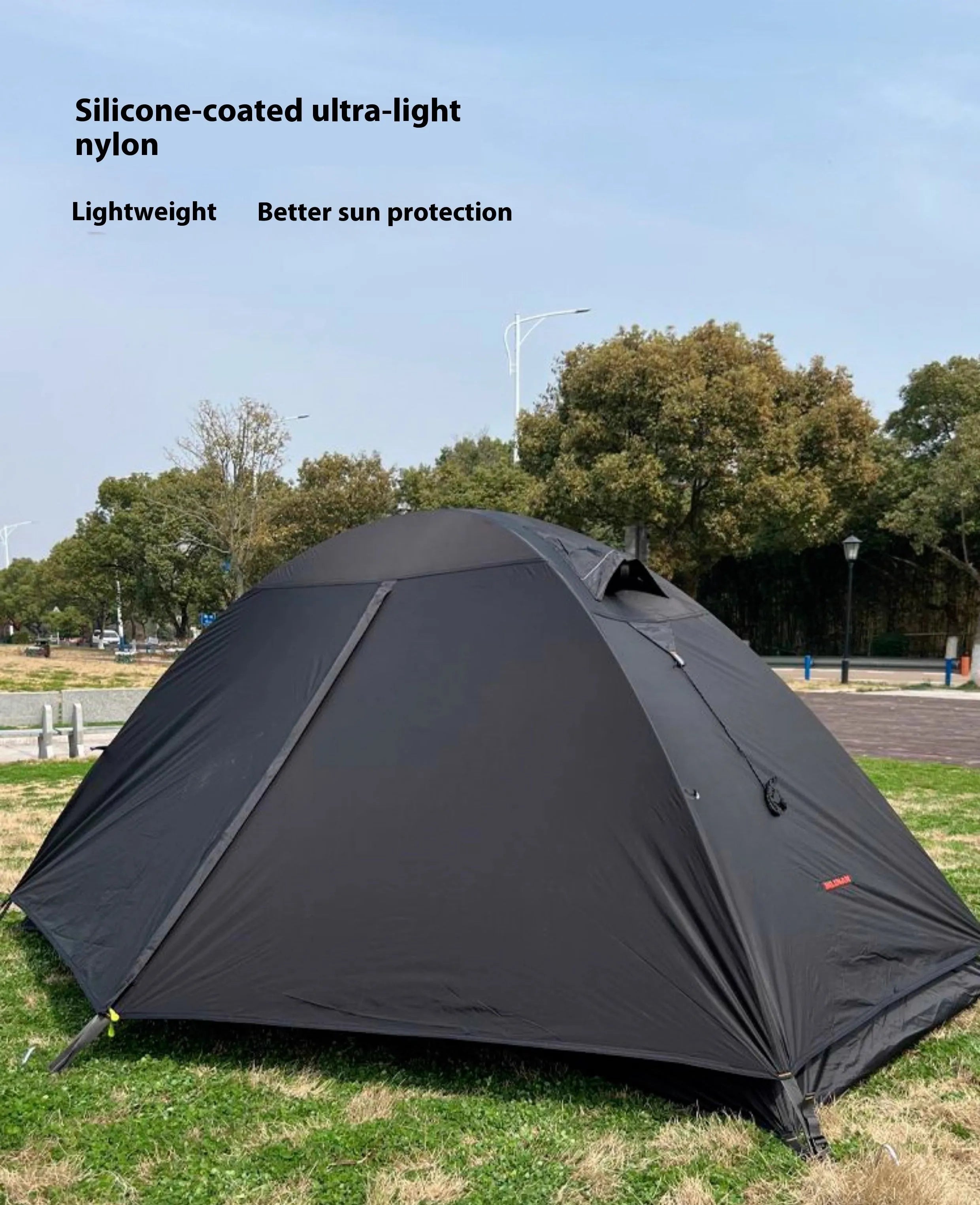 Single person orange hiking tent with aluminium poles pitched in outdoor setting