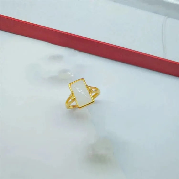 Adjustable brass gold-plated ring with a central electroplated gemstone, shown in black, green, and white colour options.
