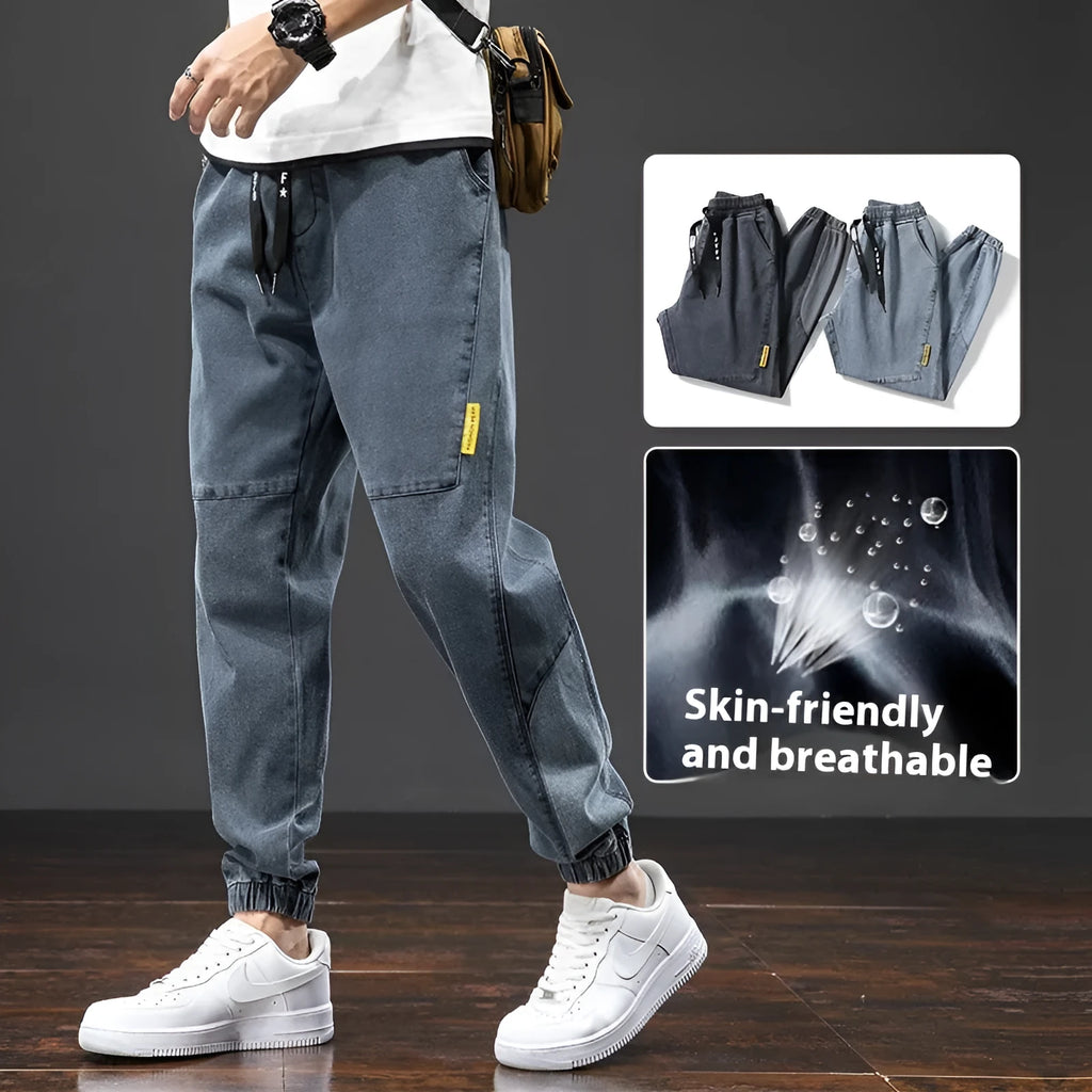 Men's loose-fit cargo jeans in blue, showing straight leg and mid-waist design on a hanger.
