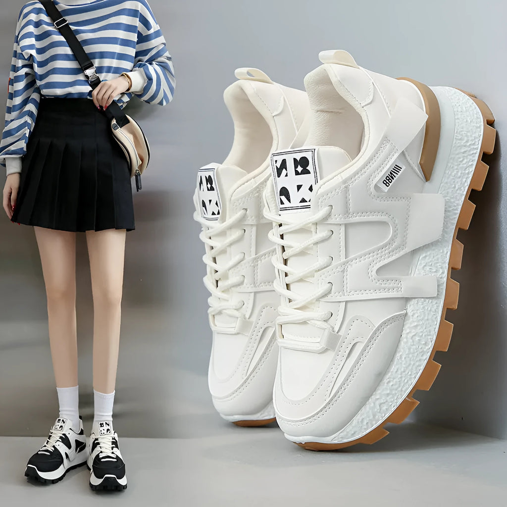Pair of low-top unisex casual sneakers in black or white with round toe and front lace-up closure.
