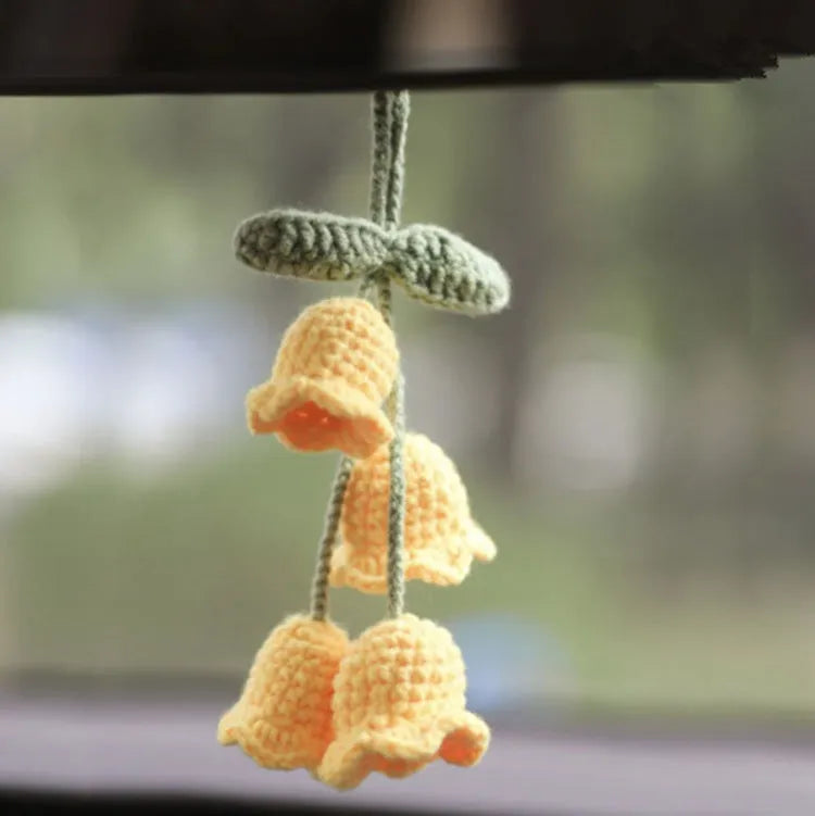 Green and white knitted wool car plant decoration basket with white hanging cord.