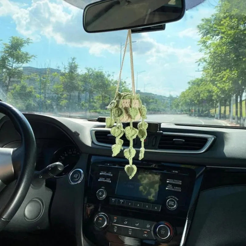 Green and white knitted wool car plant decoration basket with white hanging cord.