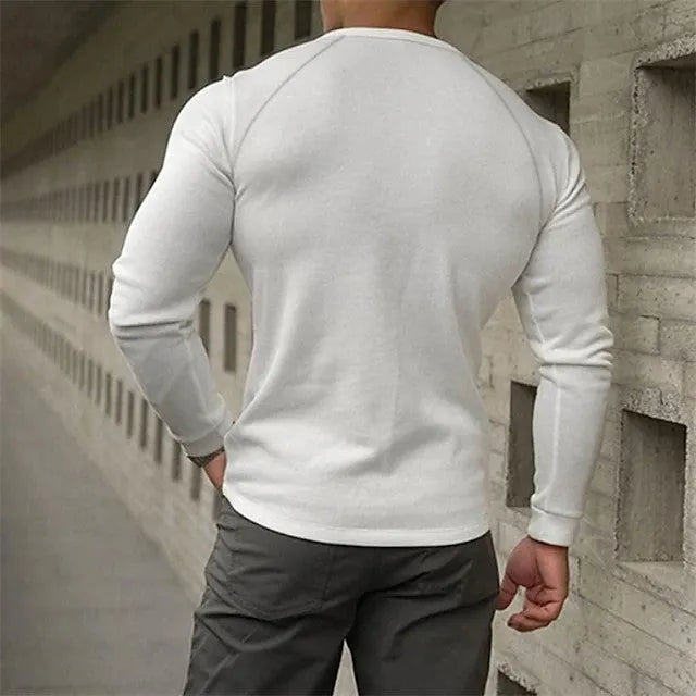Man wearing a white long-sleeved t-shirt with a Henry collar.