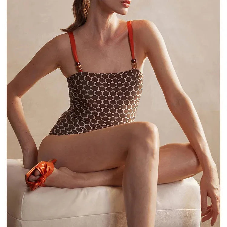 Women's printed dot pattern one-piece swimsuit with matching wrap skirt set on a mannequin