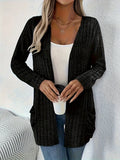 A solid colour long sleeve cardigan with pockets, shown in a loose fit on a model.