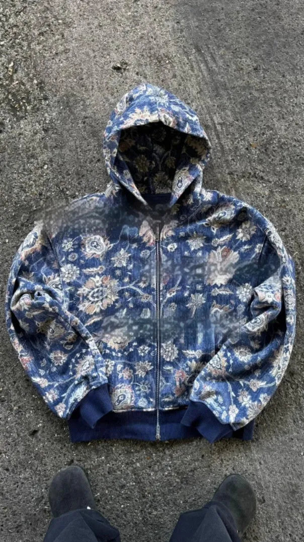 A man's loose-fitting zip-up hooded coat in red or blue with a digital print design.