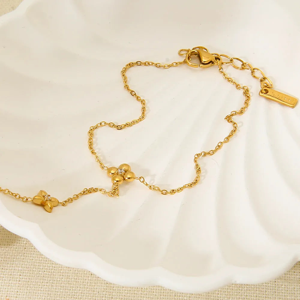 Gold stainless steel women's bracelet with geometric flower and eight-pointed star design.