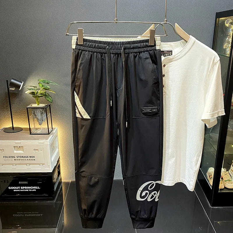 Black men's cropped trousers with banded ankle made from ice silk and cotton fabric.