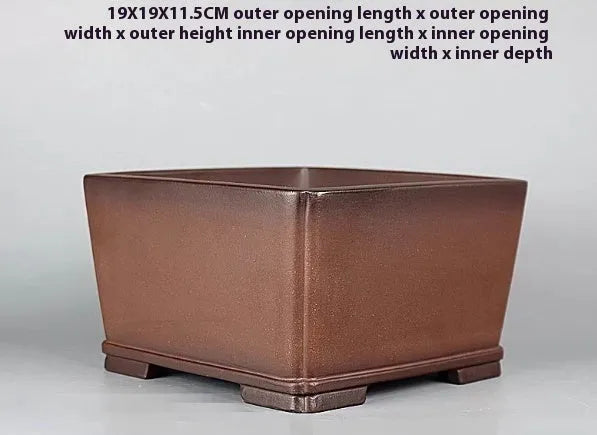 Brown handmade antique purple clay flower pot with classical style on a surface
