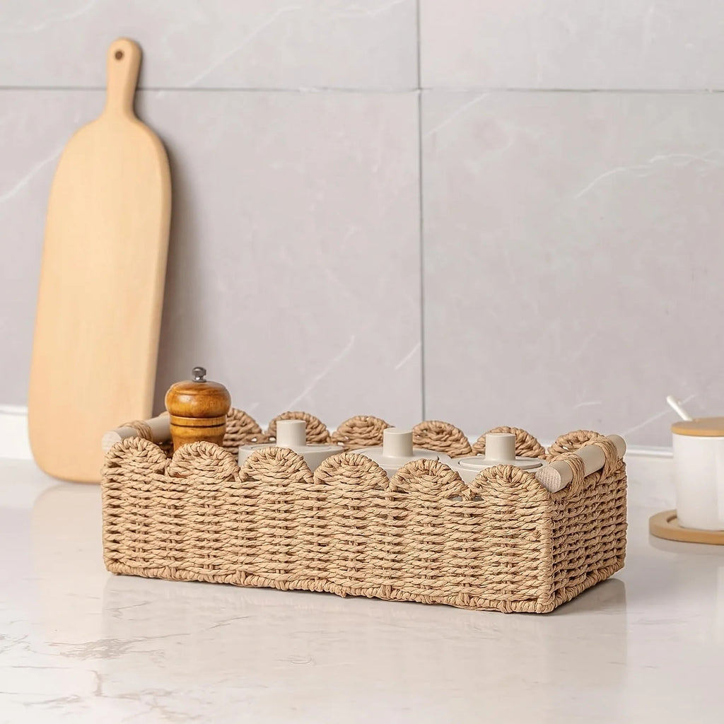 Modern simple woven paper storage basket in neutral colour on a wooden desktop holding remote controls and pens.