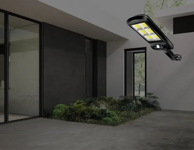 Black solar motion sensor light for outdoor garden and security lighting with PIR detection