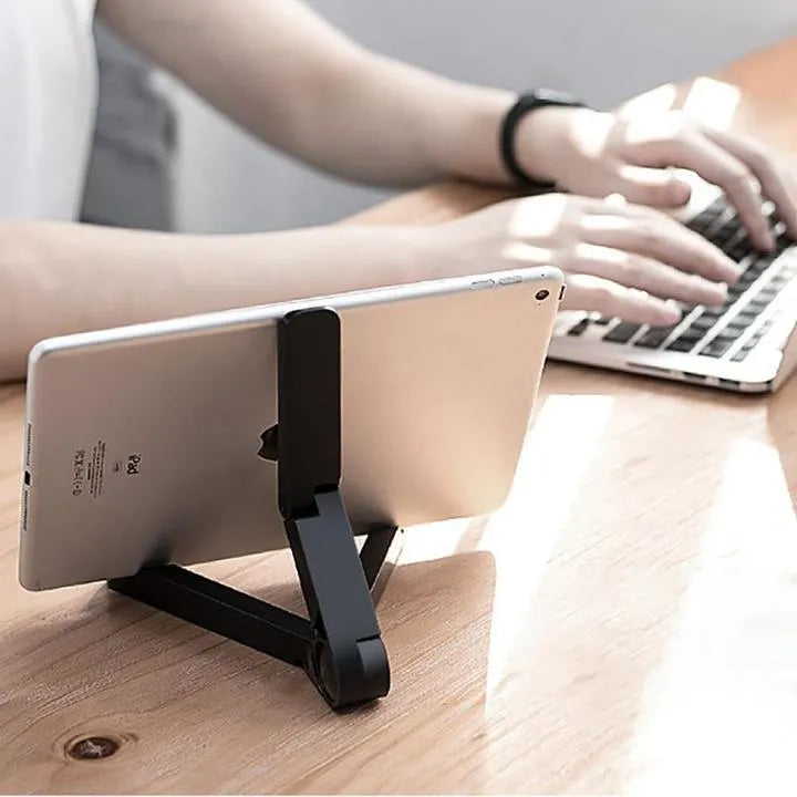 Black foldable tablet holder displaying smartphone at adjustable angle on desk