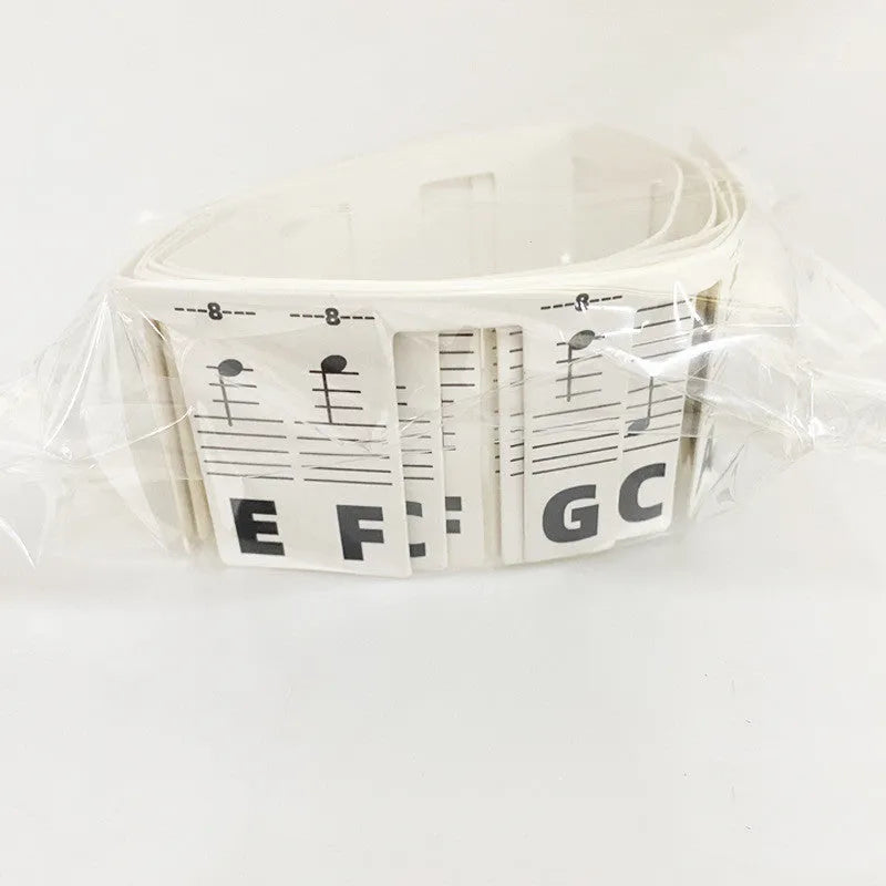 Piano keyboard note stickers on white cardboard for 88 keys, showing separate packs for black notes and colour note bars.