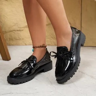 Women's black loafers with a decorative bow on the toe, made from synthetic PU material.