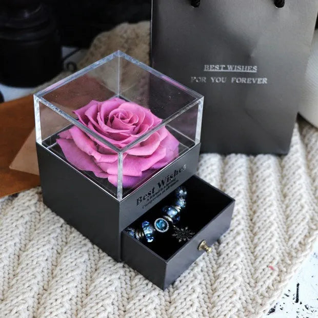 Glass eternal flower jewellery box with preserved roses and carnations inside measuring 8.5cm square