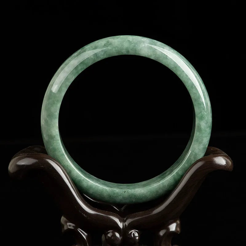 A simple deep pea green ring bracelet for women on a white background, showing its adjustable size.