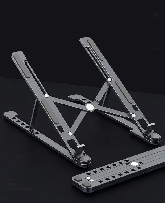 Aluminum alloy laptop stand in silver colour, folded to show its slim profile next to a 15-inch laptop.