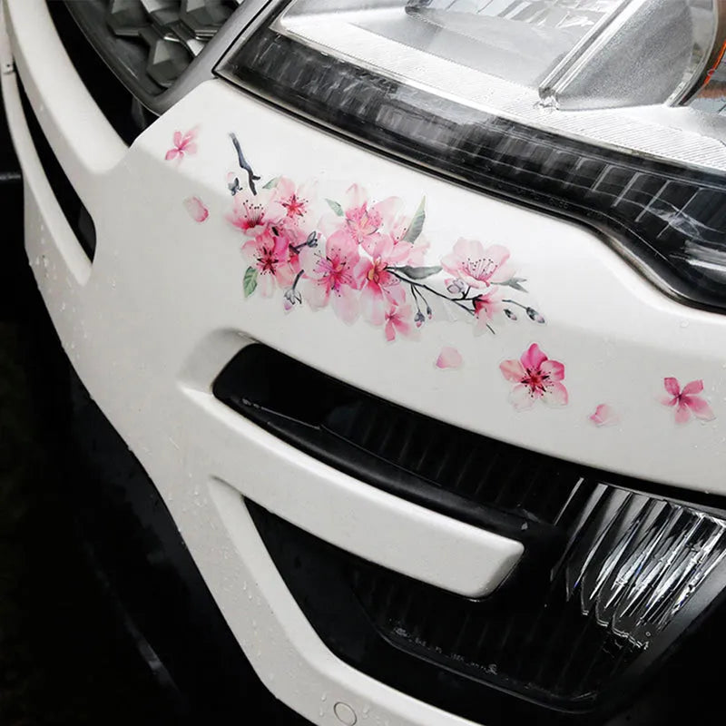 Close-up of a pink and white cherry blossom car sticker on a clear PVC backing.