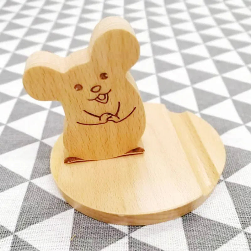Solid beech wood mobile phone stand with a decorative resin animal ornament and a coin slot.