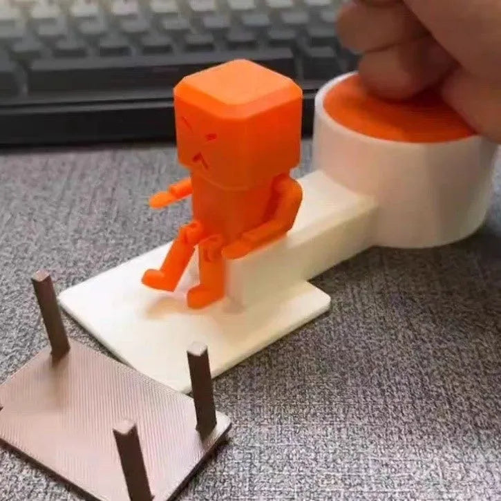 Orange plastic Take and Vent table-turning decompression toy on a desk