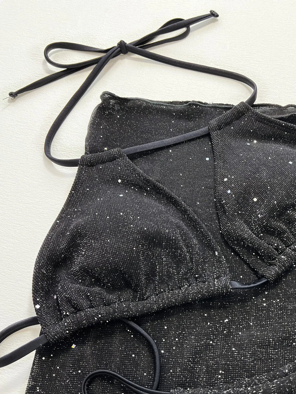 Black three-piece bikini swimsuit with matching top and shorts