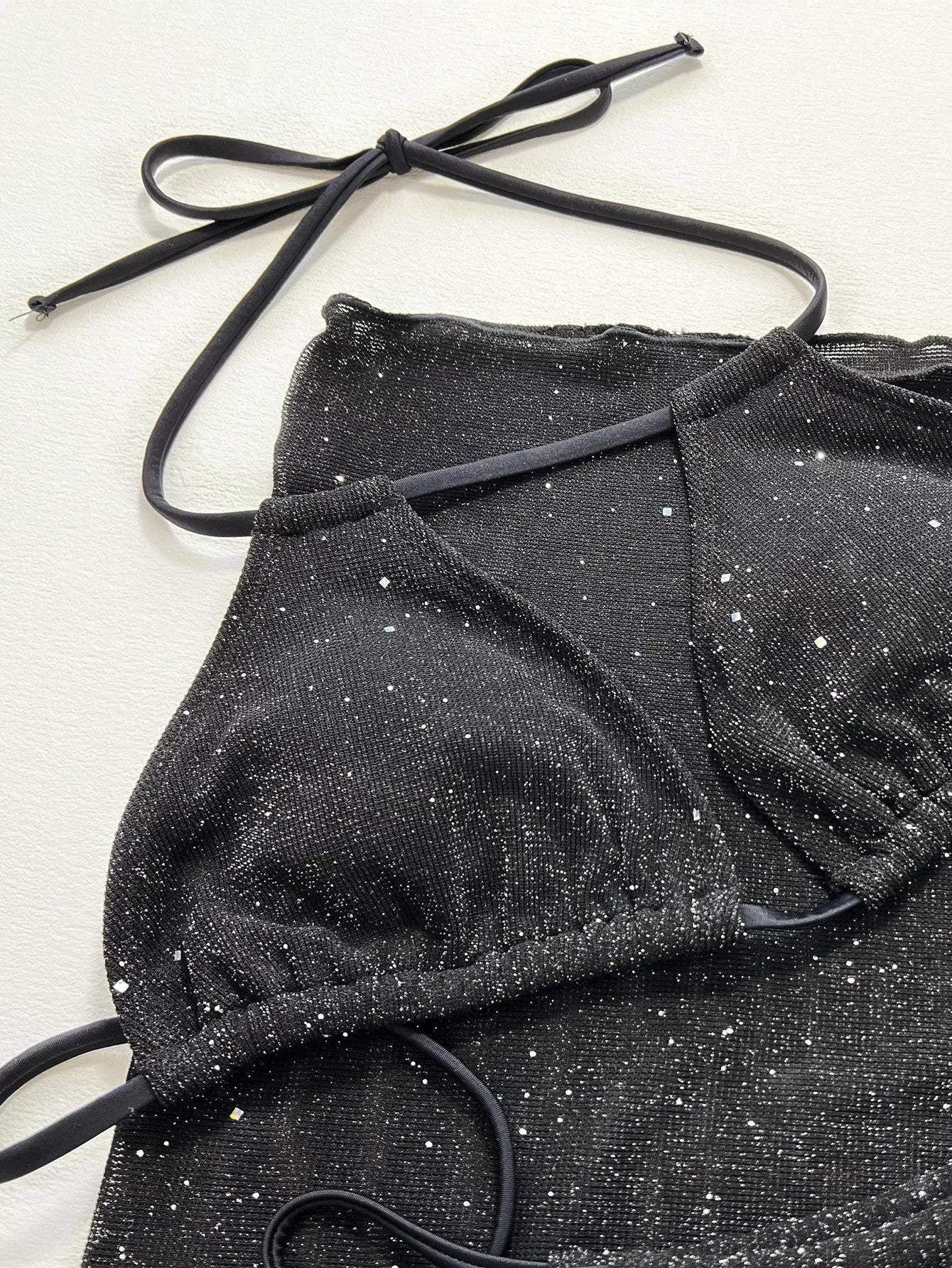 Black three-piece bikini swimsuit with matching top and shorts
