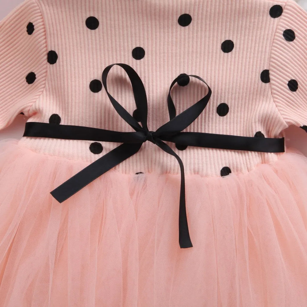 Baby girl wearing a long sleeve white lace tutu dress for a birthday party