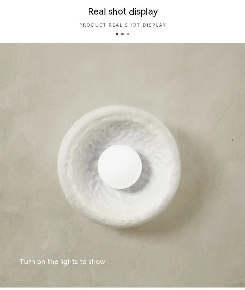 Japanese minimalist wall lamp in resin with warm light, showing three size options