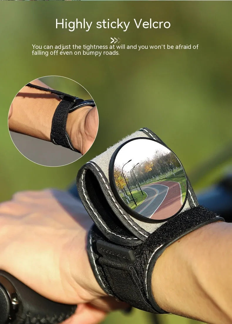 Black nylon wrist-mounted bicycle rear-view mirror with velcro strap and armoured glass reflective surface.