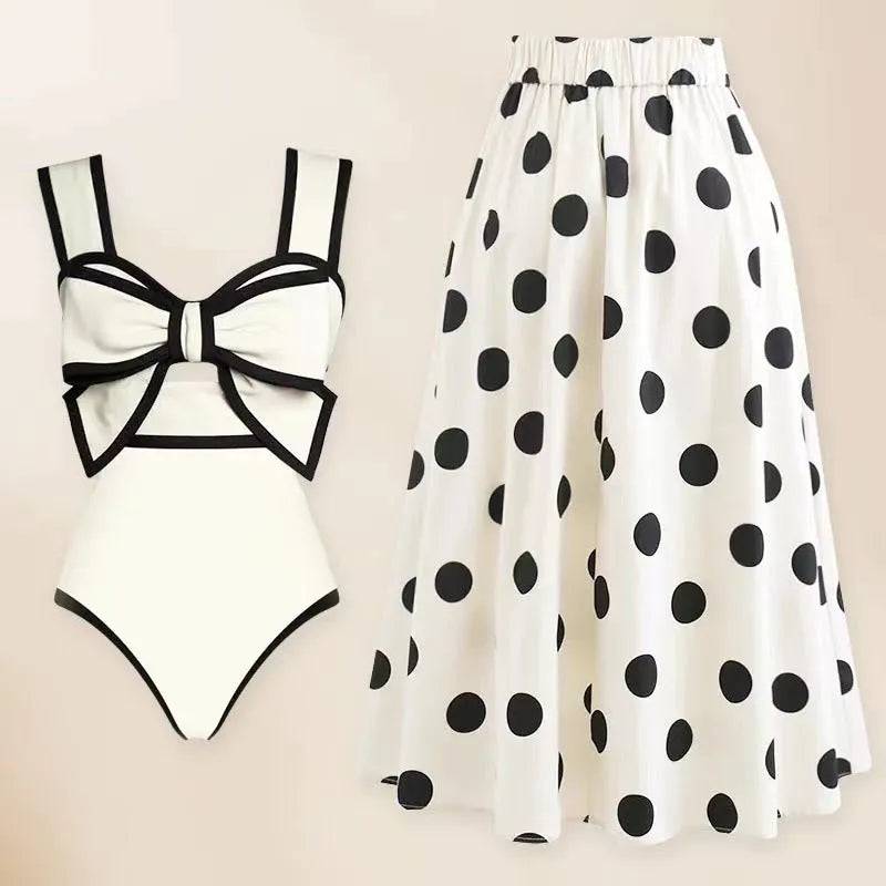 Women's black one-piece swimsuit with white round skirt and bow detail on a mannequin