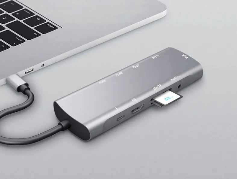 Grey aluminium USB-C docking station with HDMI, VGA, and USB 3.0 ports.