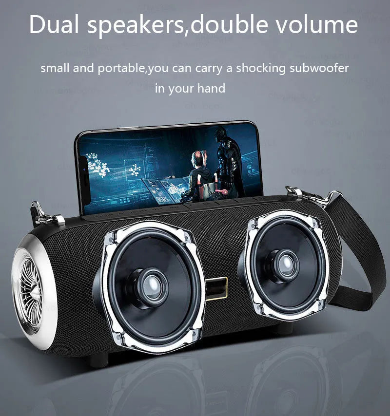 Square fabric and plastic portable Bluetooth speaker with shoulder strap and mobile phone stand.
