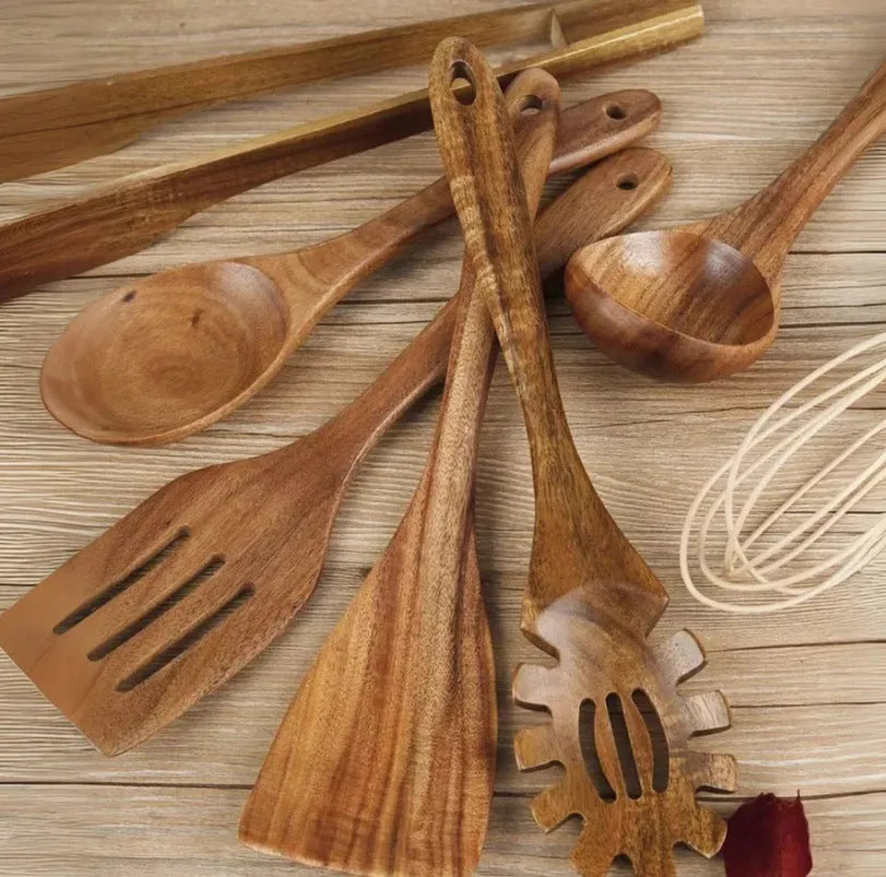 Seven wooden cooking utensils arranged together showing different shapes and sizes