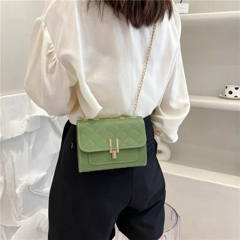 Women's solid colour crossbody bag with diamond lattice chain strap in black, shown from the front.