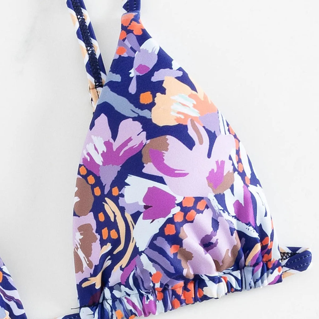 Women's floral print polyester bikini with triangle top and split-side brief bottoms.