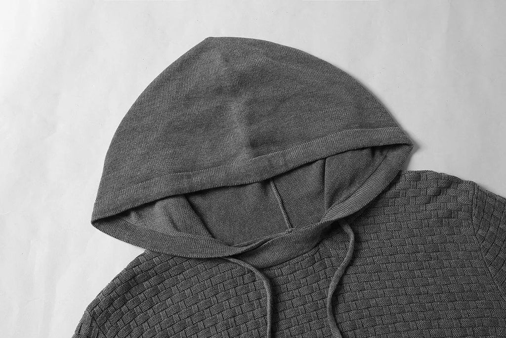 Men's black hooded sweatshirt made from cotton and polyester blend fabric on a grey background.