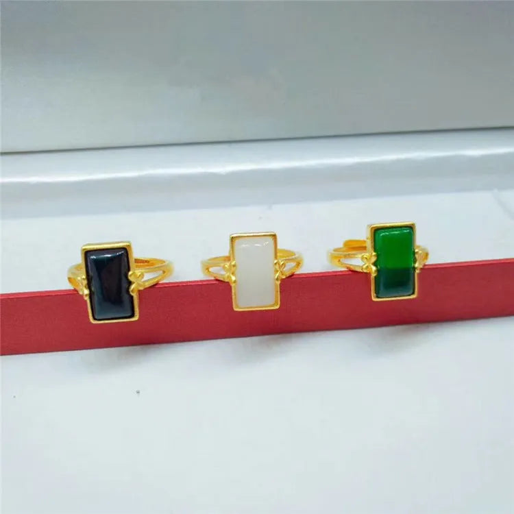 Adjustable brass gold-plated ring with a central electroplated gemstone, shown in black, green, and white colour options.