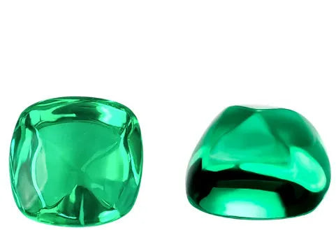 Cultivated emerald loose gemstones in round and fancy cut shapes on a dark background.