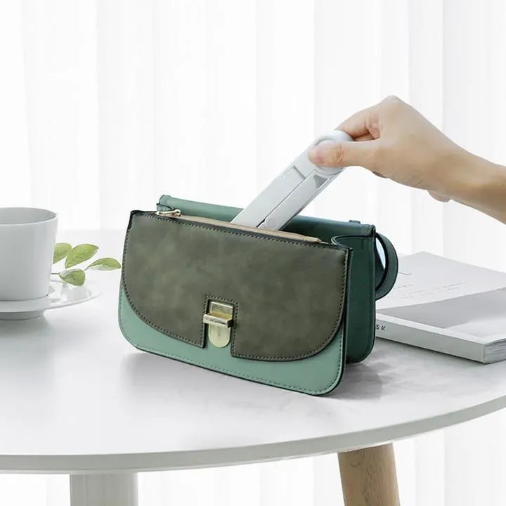 Black foldable tablet holder displaying smartphone at adjustable angle on desk