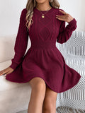 Black knit sweater dress with lantern sleeves and a twisted elastic waistband.