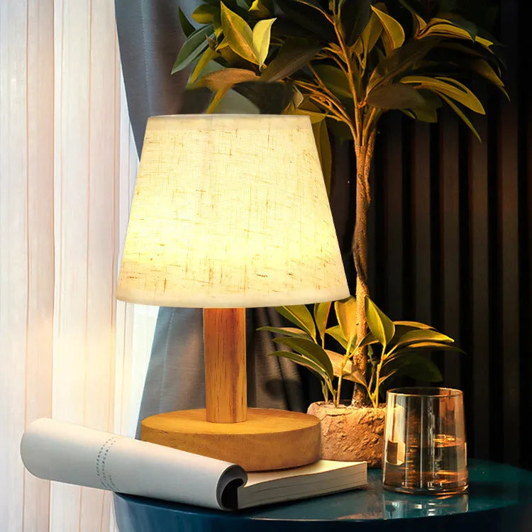Korean style table lamp with white linen shade and bamboo holder on wooden table