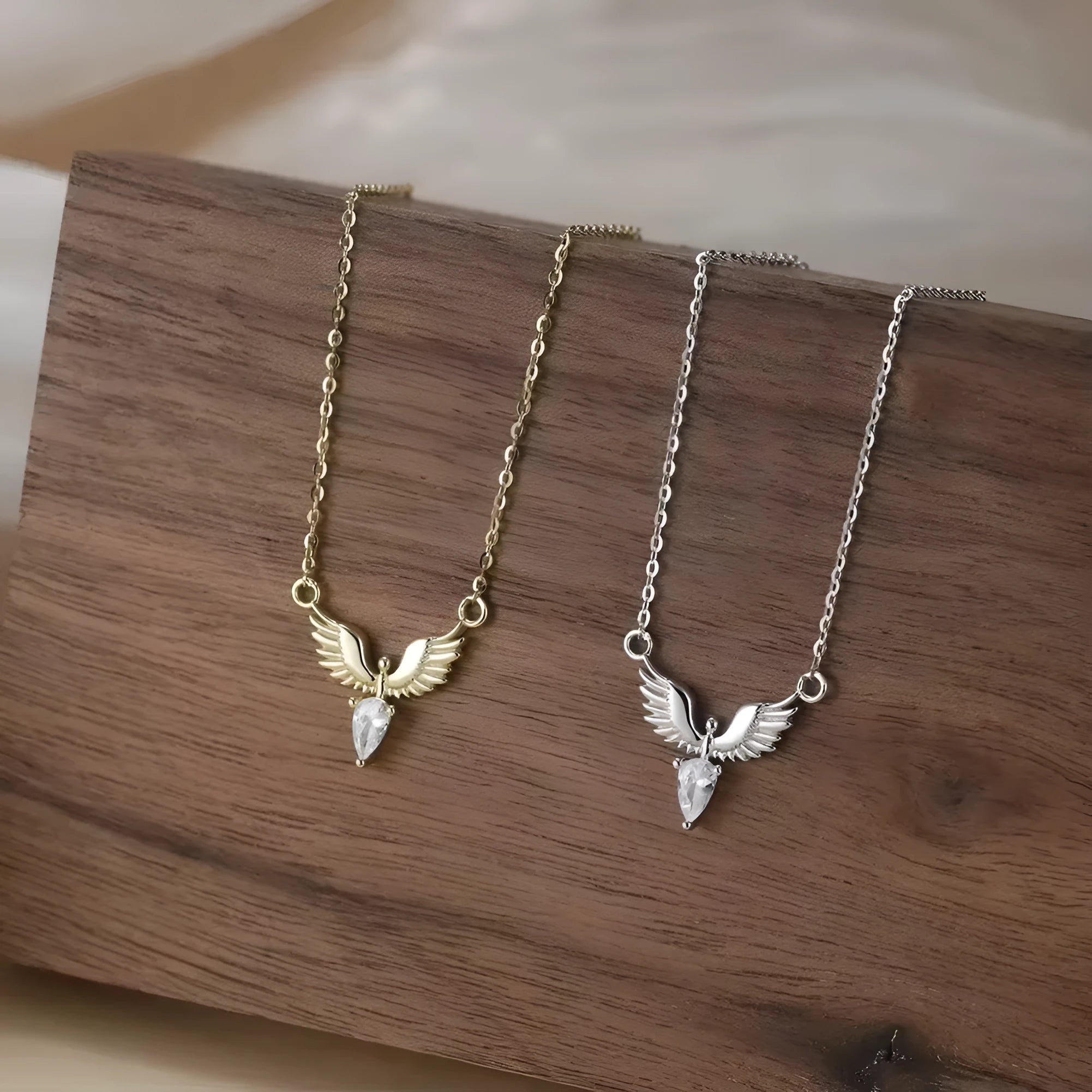 Women's eagle pendant silver necklace with O-ring chain on a grey background.
