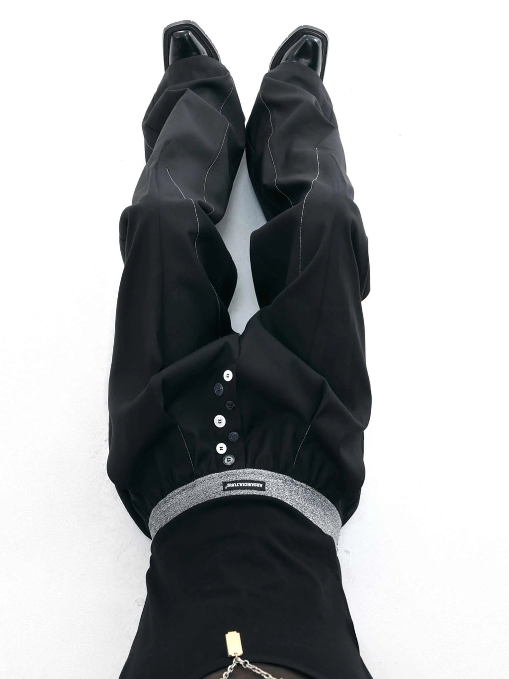 Drooping straight-leg trousers with button-open line design in black and grey colours
