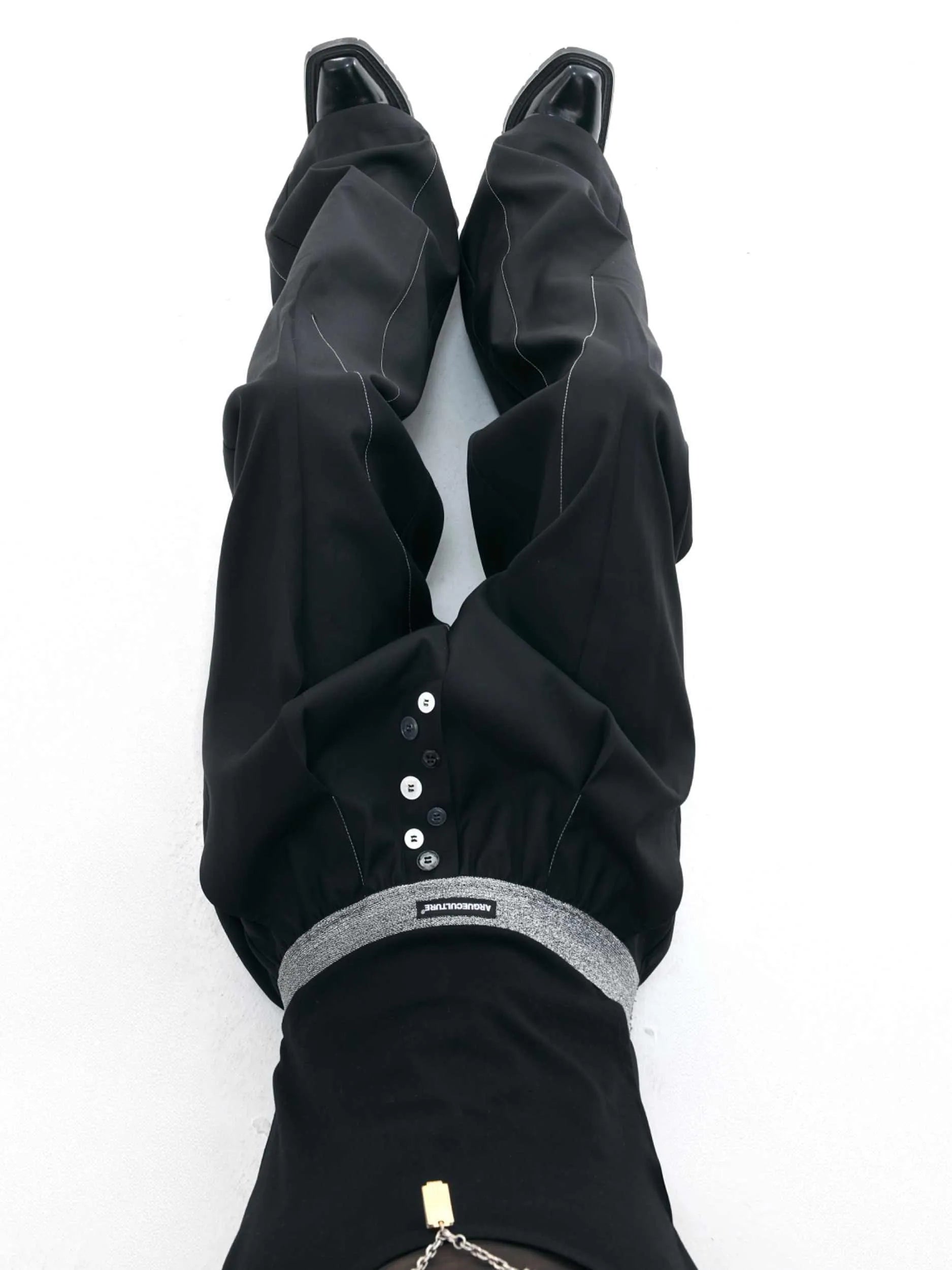 Drooping straight-leg trousers with button-open line design in black and grey colours