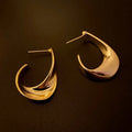 Metal twisted geometric earrings with round elements in gold or silver finish