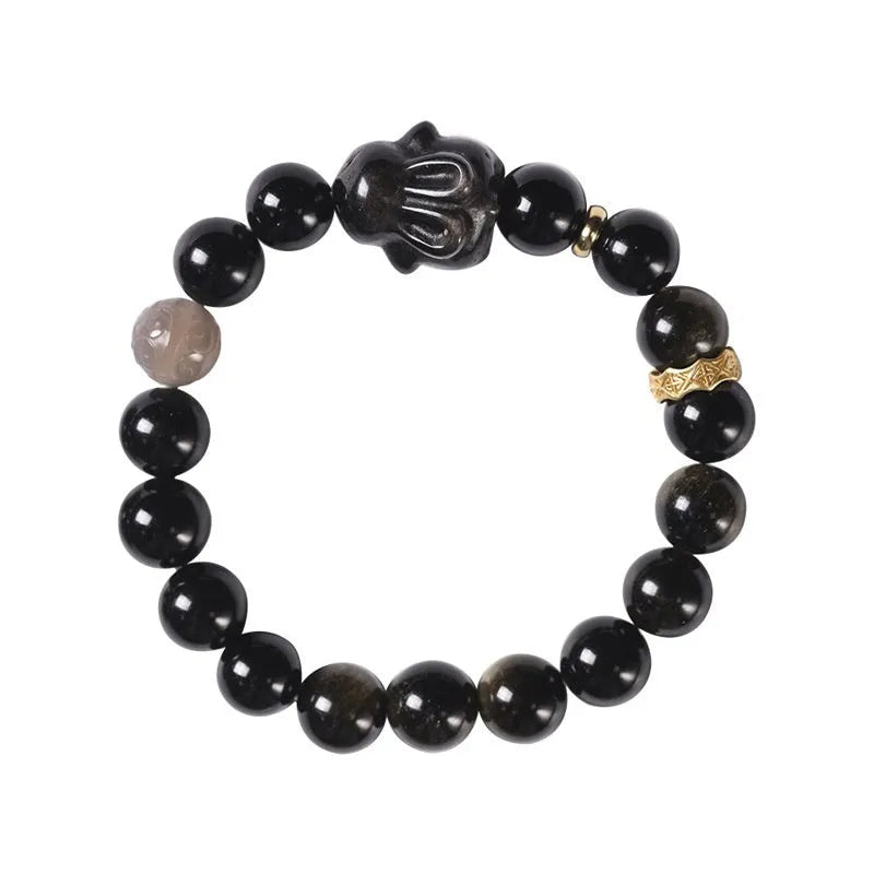 Handmade lying rabbit obsidian bracelet with grey agate beads and brass details on a wrist.