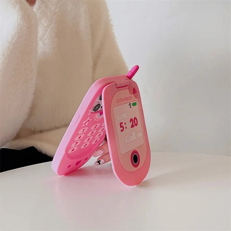 Light pink silicone flip phone case with a built-in mirror, open and showing iPhone model compatibility.