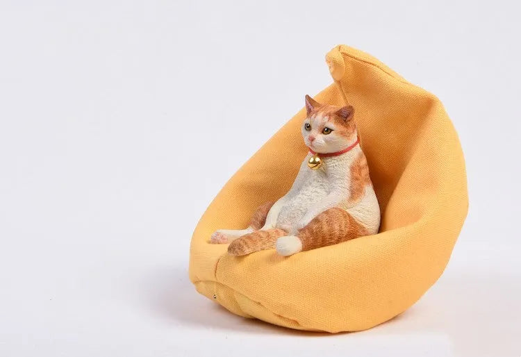 Small resin ornament of a cat sleeping on a sofa for car dashboard or shelf decoration.