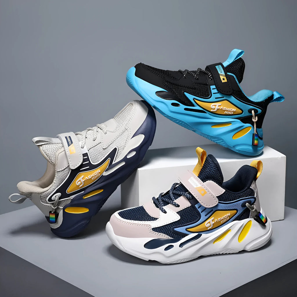 Boys' blue and black platform sports running shoes with Velcro straps on a hard ground surface.