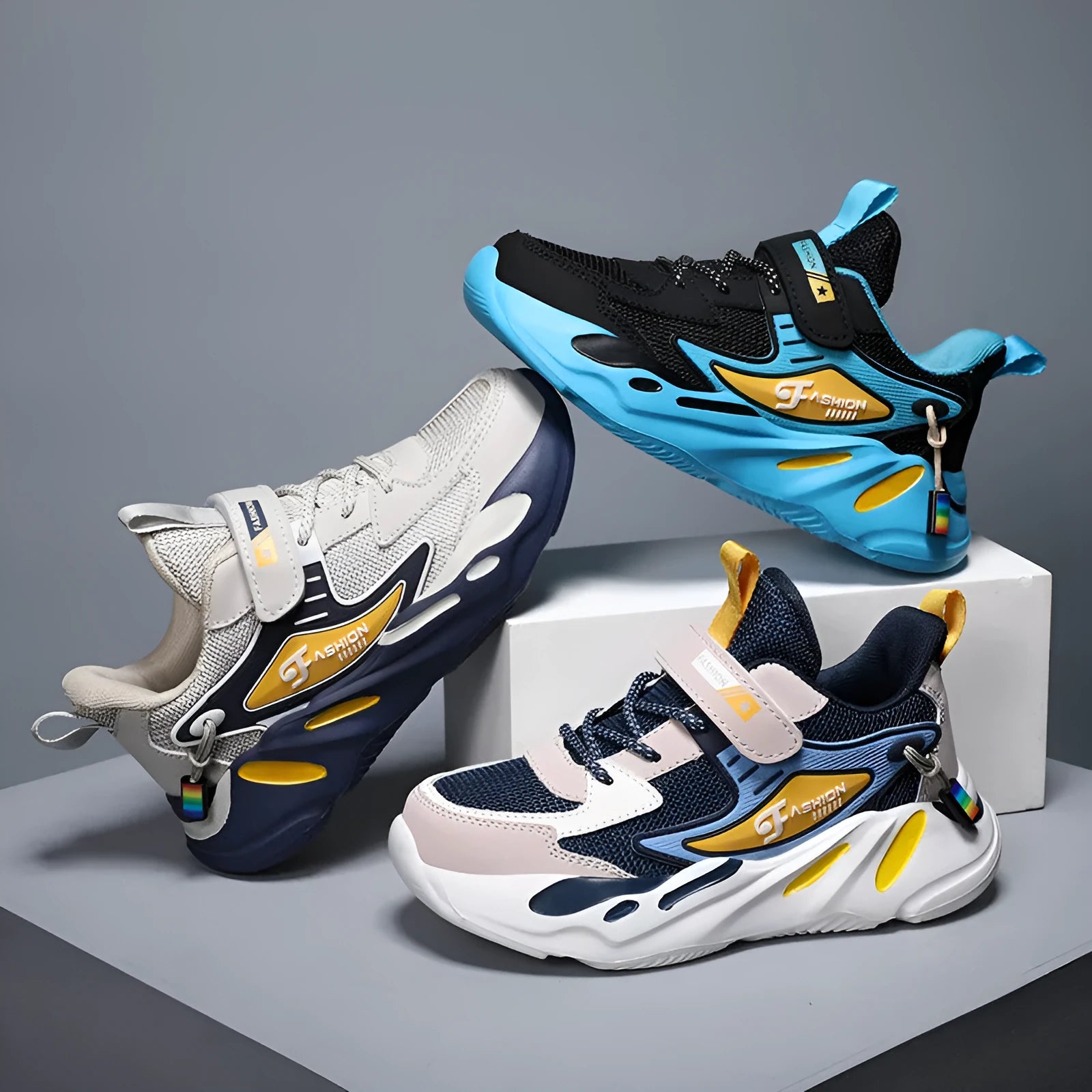 Boys' blue and black platform sports running shoes with Velcro straps on a hard ground surface.